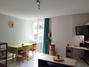 a living room with a table and a dining room at vaste T2 en Auvergne in Vic-le-Comte