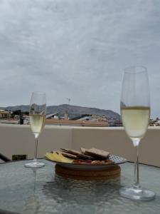 two glasses of white wine sitting on a table at K A P Home in Chios