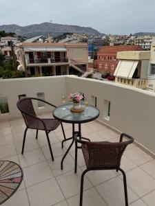 a table and chairs on a balcony with a view at K A P Home in Chios