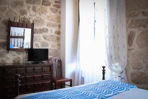 sypialnia z łóżkiem, komodą i lustrem w obiekcie Casa Pires Mateus w mieście Monsanto