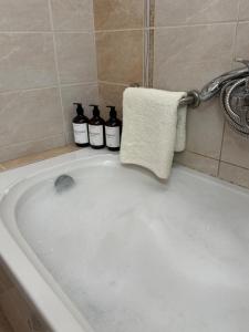 a bath tub with three bottles of soap in it at K A P Home in Chios +19 photos