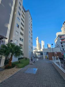 a building with a palm tree in the middle of a courtyard at Apto.napraia BEACH 901 em Piçarras com vista mar in Piçarras