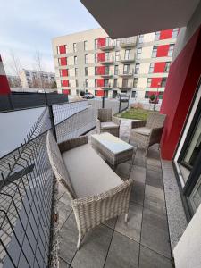 a balcony with chairs and tables and a building at Aura Apartamenty 3 in Brzeg