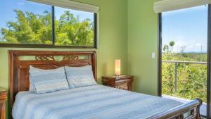 a bedroom with a bed and a large window at Villa Kiskadee - Beautiful Mountain Views with Private Pool in Quepos +7 photos