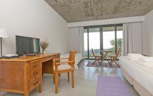 a bedroom with a desk with a television and a bed at Quinta Raposeiros - Ocean View CountryHouse Ericeira in Santo Isidoro