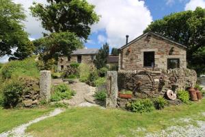 an old stone house with a garden in front of it at Nuthatch Cottage in Cardinham