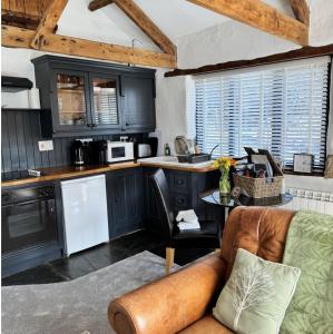 a kitchen with a couch and a table in a room at Nuthatch Cottage in Cardinham