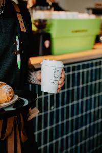 a person is holding a coffee cup on a counter at Alt Hotel Calgary University District in Calgary