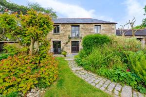 a stone house with a garden in front of it at Tawnawood in Cardinham