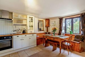 a large kitchen with a wooden table and a table sidx sidx sidx at Tawnawood in Cardinham +7 photos