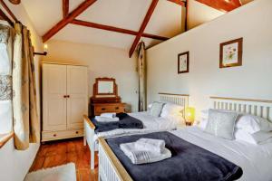 two twin beds in a room with a mirror at Tawnawood in Cardinham