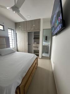 a bedroom with a large bed and a flat screen tv at Apartamento completo cerca del centro in Montería