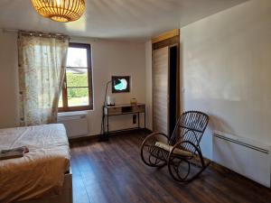 a bedroom with a bed and a chair and a window at La maison Argonnaise in beaulieu en argonne