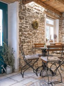 a stone wall with two chairs and a table at Guesthouse Centrum B&B in Izola