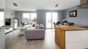 a kitchen and living room with a couch and a table at Prestige House Jacuzzi & Sauna in Gdańsk