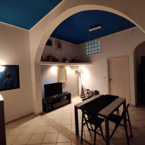 a living room with a blue ceiling and a table at Casaitalia in Capilungo