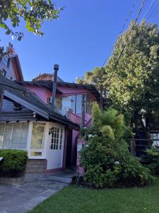 a pink house with a white door at Pousada Centro in Gramado