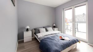 a bedroom with a bed and a large window at Prestige House Jacuzzi & Sauna in Gdańsk