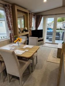 a dining room with a table and chairs and a television at Tattershall Lakes 49 Larch View in Tattershall
