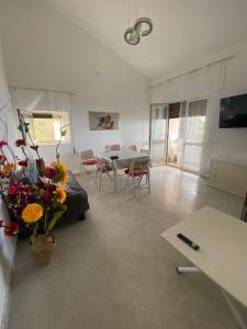 a living room with a couch and a table with flowers at Ranieli Apartments - Pool & View near Tropea in Drapia