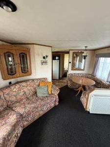 a living room with a couch and a table at Holiday Home Arbroath in Arbroath