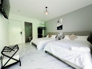 two beds in a bedroom with white walls and white tile floors at Downtown Suites - Hotel Boutique by Maraf in Cancún +29 photos