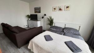 a bedroom with a bed and a couch at THE RIVERSIDE APARTMENT with Balcony in Prague