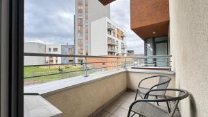 a balcony with two chairs and a view of a building at THE RIVERSIDE APARTMENT with Balcony in Prague