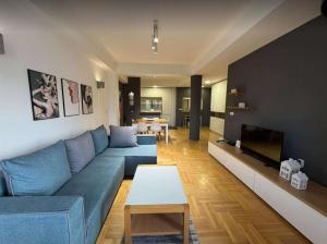 a living room with a blue couch and a tv at Apartment CityHeart in Ohrid