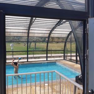 a man standing in front of a swimming pool at camping sous le moulin in Condes