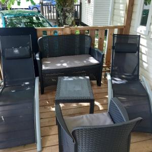 three chairs and a table on a patio at camping sous le moulin in Condes