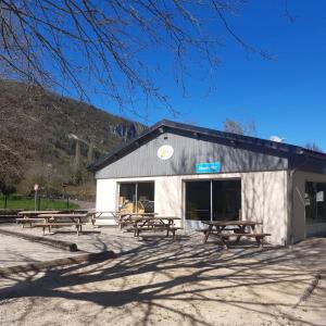 a group of picnic tables in front of a building at camping sous le moulin in Condes