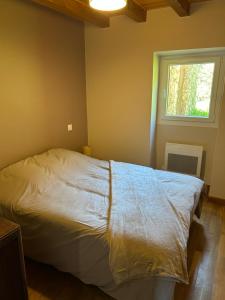 a bedroom with a white bed with a window at Gîte Les Vignes au Cheylard in Le Cheylard