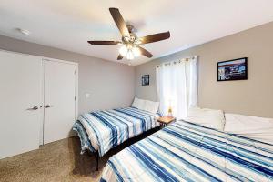 a bedroom with two beds and a ceiling fan at Vineyards 2909 #3 in Branson