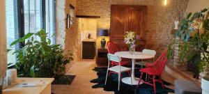 a dining room with a table and red chairs at location 24h du Mans in La Ferté-Bernard