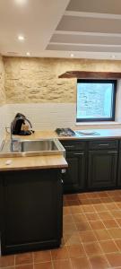 a kitchen with a sink and a counter with a window at location 24h du Mans in La Ferté-Bernard