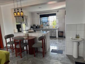 a kitchen with a table and some chairs and a sink at Elp Living in Hoima +11 photos