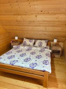 a bed in a room with two night stands and two lamps at Brvnare Nikolić in Zlatibor