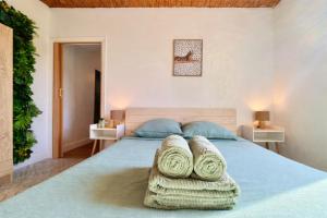 a bedroom with a large bed with towels on it at " Verdun Paradise " Jardin - Salle de Sport - Salle de Jeux in Verdun-sur-Garonne
