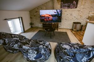 a living room with a couch and a flat screen tv at Le Loft - Classé 5 ÉTOILES in Mussidan