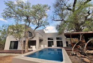 an exterior view of a house with a swimming pool at Canopy Lodge Marloth in Marloth Park