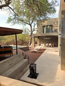 a patio with a bench and a house at Canopy Lodge Marloth in Marloth Park