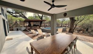 a dining room with a table and a swimming pool at Canopy Lodge Marloth in Marloth Park