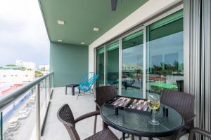 a balcony with a table with a glass of wine at La Poza Suites in Isla Mujeres