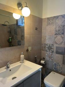 a bathroom with a sink and a toilet and a mirror at Minimalist Serenity Vravrona - Airport Stay in Vravrona +22 photos
