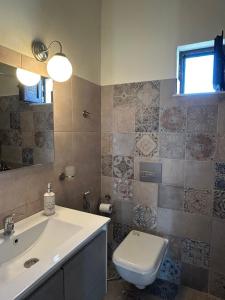 a bathroom with a toilet and a sink at Minimalist Serenity Vravrona - Airport Stay in Vravrona