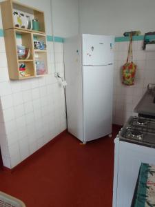 a kitchen with a white refrigerator and a stove at casa charme e praticidade in Campos do Jordão
