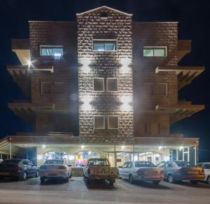 un edificio con coches estacionados frente a él en Moon Cnter, en Majdal Shams