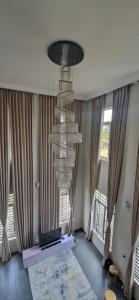 a living room with a chandelier in front of windows at The white house in Douala +62 photos