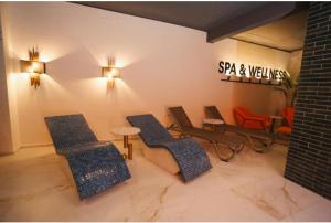 a room with three chairs and a sign on the wall at BK Apartman in Zlatibor